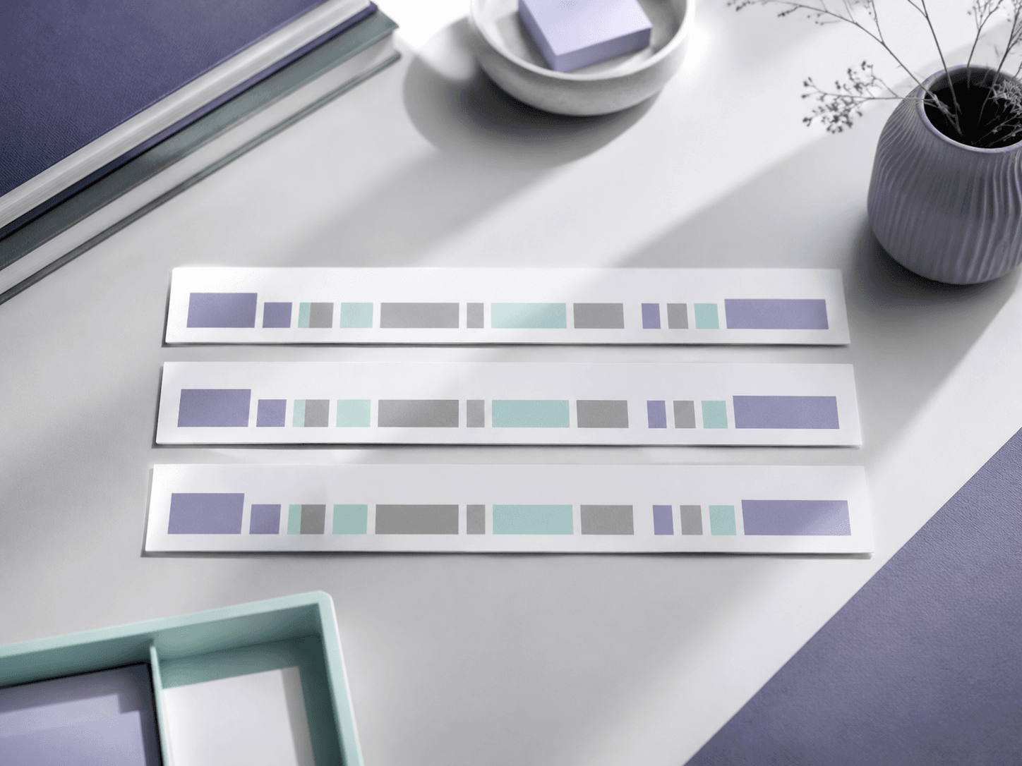 Three pale card strips in strict parallel with blocked violet, mint and grey segments