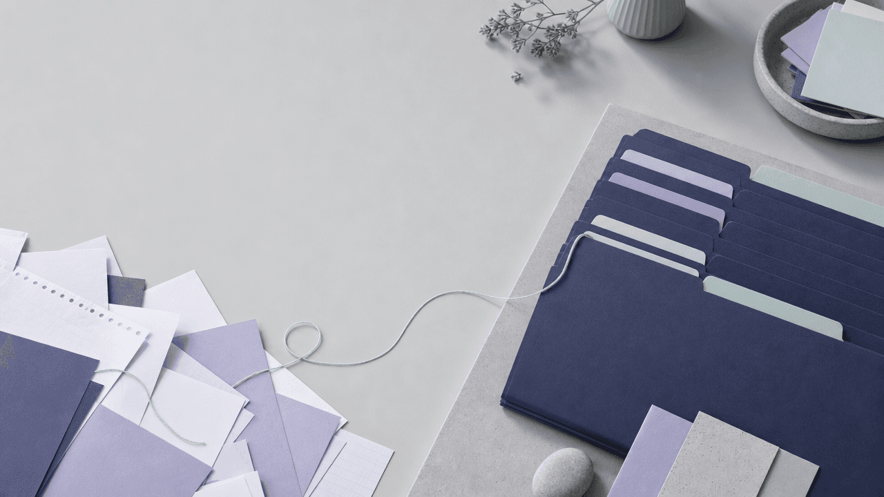 Loose scattered paper sheets on the left resolving into neatly tabbed indigo folders on the right, joined by one mint thread